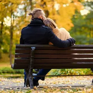 Couple in fall on bench