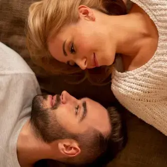 Couple lying on ground looking at each other