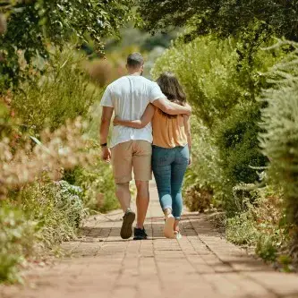 Couple walking arm in arm in park